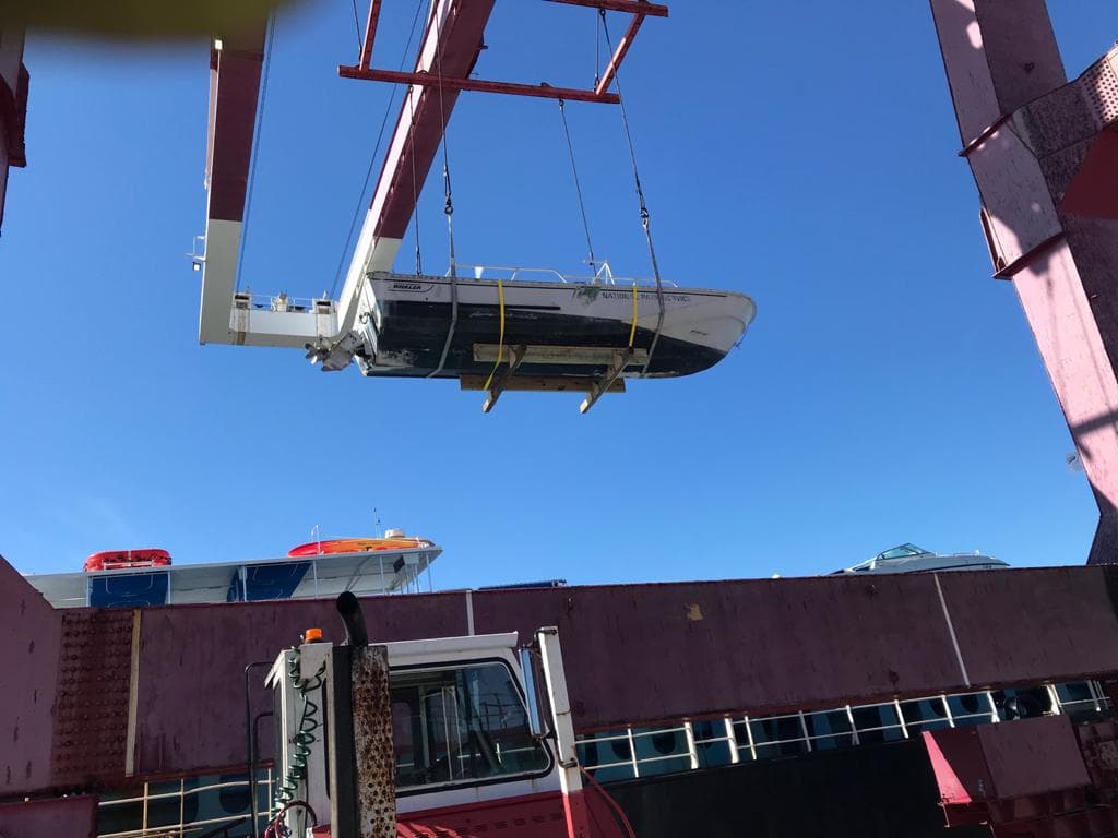 Boston Whaler being craned onto a Bermuda-bound cargo ship