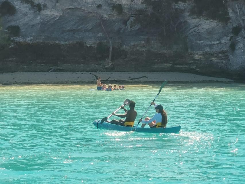 Tandem kayak gliding through a Bermuda cliff cove on a BDA Boats charter